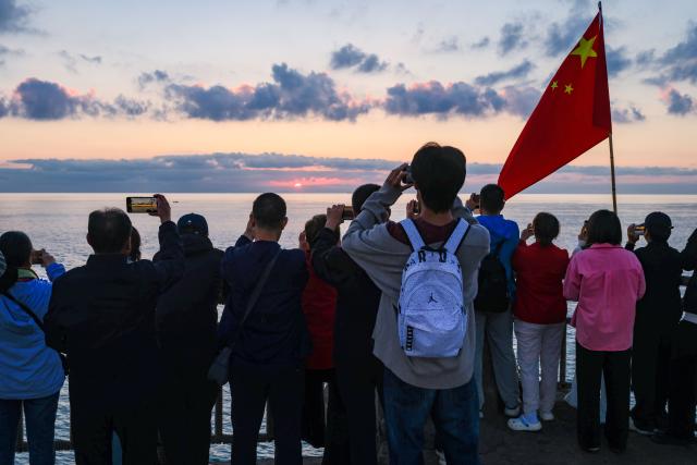 (261010) -- RONGCHENG, Oct. 10, 2026 (Xinhua) -- People capture sea views at sunrise in Rongcheng, east China's Shandong Province, Oct. 10, 2026. (Xinhua/Chen Yehua)