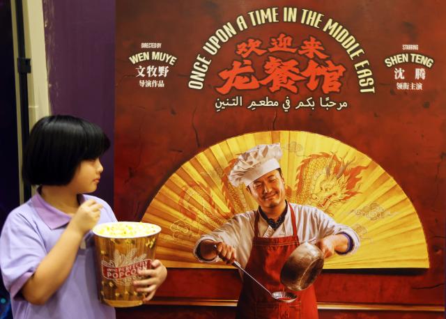 (261010) -- LOS ANGELES, Oct. 10, 2026 (Xinhua) -- A child looks at a poster of the Chinese film "Once Upon a Time in the Middle East" at a theater in Los Angeles, the United States, Oct. 9, 2026. (Photo by Zeng Hui/Xinhua)