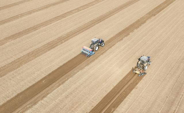 (261010) -- BEIJING, Oct. 10, 2026 (Xinhua) -- An aerial drone photo taken on Oct. 10, 2026 shows farm machinery sowing wheat in the fields at Weiqiao Town in Zouping City, east China's Shandong Province. As autumn sets in, farmers across China make the most of the farming season to work to ensure stable grain production. (Photo by Dong Naide/Xinhua)