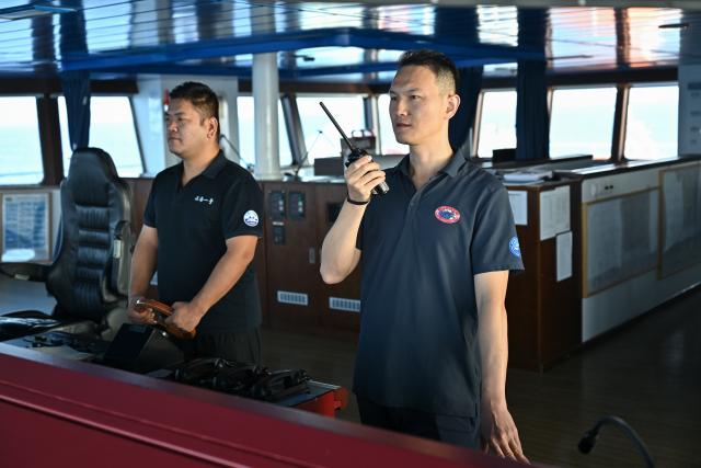 (261010) -- ABOARD RESEARCH VESSEL DEEP SEA NO. 1, Oct. 10, 2026 (Xinhua) -- Captain Zhao Xin (R) holds a handheld radio as third officer Song Yunduo steers the research vessel Deep Sea No. 1 into position for the launch of the manned deep-sea submersible Jiaolong in the western Pacific Ocean, on Oct. 10, 2026. China's research vessel Deep Sea No. 1, carrying manned deep-sea submersible Jiaolong, arrived at East Caroline Basin in the western Pacific Ocean on Saturday for deep-sea scientific research.
   This marks the 466th dive of Jiaolong, with a planned diving depth of about 4,500 meters. (Xinhua/Li Xin)