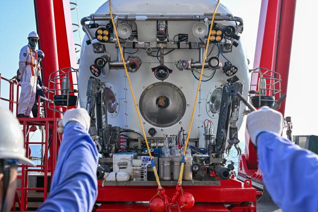 (261010) -- ABOARD RESEARCH VESSEL DEEP SEA NO. 1, Oct. 10, 2026 (Xinhua) -- Submersible pilot Fu Wentao in cabin makes 'OK' hand gestures to members of the support team before the dive of the manned deep-sea submersible Jiaolong aboard the research vessel Deep Sea No. 1 in the western Pacific Ocean, on Oct. 10, 2026. China's research vessel Deep Sea No. 1, carrying manned deep-sea submersible Jiaolong, arrived at East Caroline Basin in the western Pacific Ocean on Saturday for deep-sea scientific research.
   This marks the 466th dive of Jiaolong, with a planned diving depth of about 4,500 meters. (Xinhua/Li Xin)