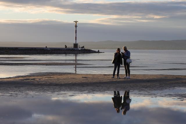 (261010) -- SIOFOK, Oct. 10, 2026 (Xinhua) -- People relax by the shore of Lake Balaton in Siofok, Hungary, Oct. 9, 2026. (Xinhua/Hu Zhixuan)