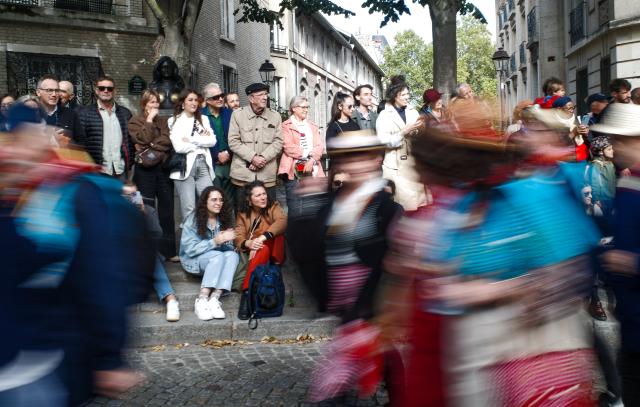 (261010) -- PARIS, Oct. 10, 2026 (Xinhua) -- People watch a parade during the Montmartre Grape Harvest Festival in Paris, France, Oct. 10, 2026. The 93rd edition of the Montmartre Grape Harvest Festival runs from Oct. 7 to 11, featuring a grand parade, musical performances and other festivities. (Xinhua/Wu Huiwo)