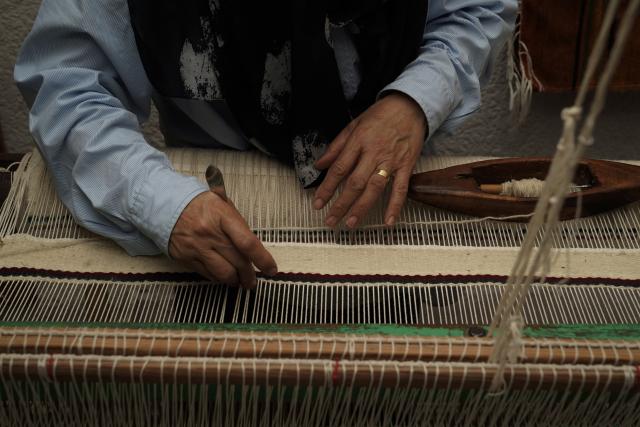 (261010) -- TRIPOLI, Oct. 10, 2026 (Xinhua) -- Aisha Madi weaves on a loom in a workshop in Tripoli, Libya, Sept. 29, 2026. TO GO WITH "Feature: Thread by thread, Libyan women keep an age-old craft alive" (Photo by Hazem Turkia/Xinhua)