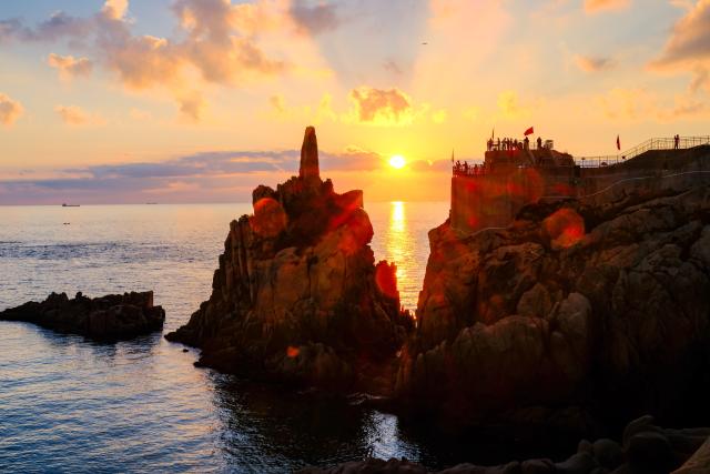 (261011) -- BEIJING, Oct. 11, 2026 (Xinhua) -- People capture sea views at sunrise in Rongcheng, east China's Shandong Province, Oct. 10, 2026. (Xinhua/Chen Yehua)