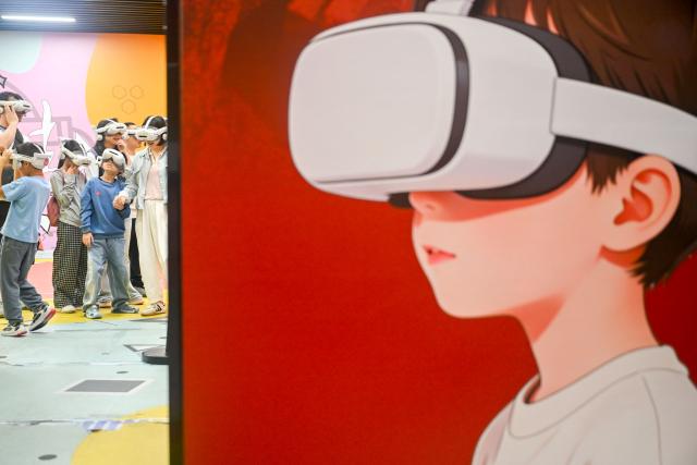 (261011) -- ZUNYI, Oct. 11, 2026 (Xinhua) -- Tourists experience VR devices at the Zunyi Meeting memorial hall in Zunyi City, southwest China's Guizhou Province, Oct. 1, 2026. (Photo by Yuan Fuhong/Xinhua)