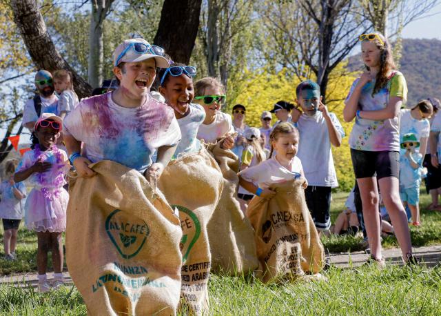 (261011) -- CANBERRA, Oct. 11, 2026 (Xinhua) -- Children take part in a sack race during a color run event in Canberra, Australia, Oct. 11, 2026. (Photo by Chu Chen/Xinhua)