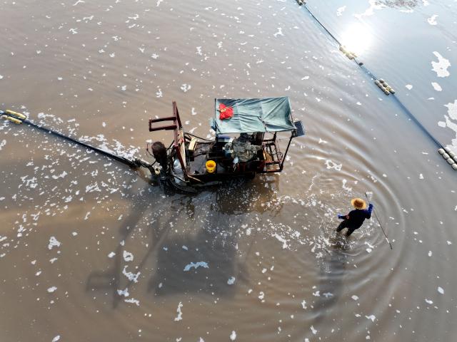 (261011) -- LIANYUNGANG, Oct. 11, 2026 (Xinhua) -- A drone photo taken on Oct. 11, 2026 shows workers operating in a salt field in Lianyungang City, east China's Jiangsu Province. Autumn salt harvest is underway in coastal salt fields in Lianyungang. (Photo by Wang Chun/Xinhua)