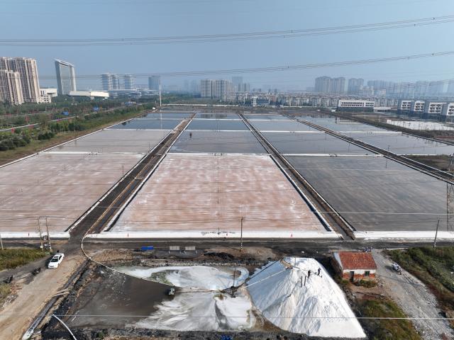 (261011) -- LIANYUNGANG, Oct. 11, 2026 (Xinhua) -- A drone photo taken on Oct. 11, 2026 shows workers operating in a salt field in Lianyungang City, east China's Jiangsu Province. Autumn salt harvest is underway in coastal salt fields in Lianyungang. (Photo by Wang Chun/Xinhua)
