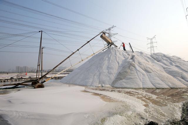(261011) -- LIANYUNGANG, Oct. 11, 2026 (Xinhua) -- A worker operates in a salt field in Lianyungang City, east China's Jiangsu Province, Oct. 11, 2026. Autumn salt harvest is underway in coastal salt fields in Lianyungang. (Photo by Wang Chun/Xinhua)