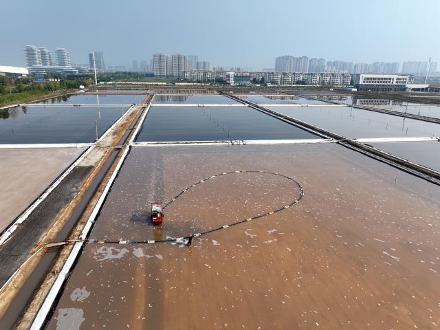 (261011) -- LIANYUNGANG, Oct. 11, 2026 (Xinhua) -- A drone photo taken on Oct. 11, 2026 shows workers operating in a salt field in Lianyungang City, east China's Jiangsu Province. Autumn salt harvest is underway in coastal salt fields in Lianyungang. (Photo by Wang Chun/Xinhua)