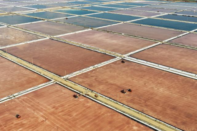 (261011) -- LIANYUNGANG, Oct. 11, 2026 (Xinhua) -- An aerial drone photo taken on Oct. 10, 2026 shows workers operating in salt fields in Lianyungang City, east China's Jiangsu Province. Autumn salt harvest is underway in coastal salt fields in Lianyungang. (Photo by Wang Jianmin/Xinhua)