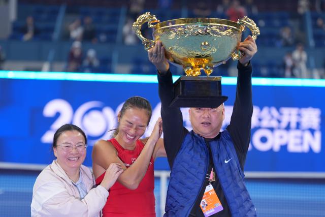 (261011) -- BEIJING, Oct. 11, 2026 (Xinhua) -- Zheng Qinwen (C) poses with her parents during the awarding ceremony after the women's singles final between Zheng Qinwen of China and Mirra Andreeva of Russia at 2026 China Open tennis tournament in Beijing, China, Oct. 11, 2026. (Xinhua/Sun Fei)
