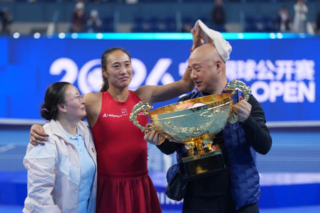 (261011) -- BEIJING, Oct. 11, 2026 (Xinhua) -- Zheng Qinwen (C) poses with her parents during the awarding ceremony after the women's singles final between Zheng Qinwen of China and Mirra Andreeva of Russia at 2026 China Open tennis tournament in Beijing, China, Oct. 11, 2026. (Xinhua/Sun Fei)