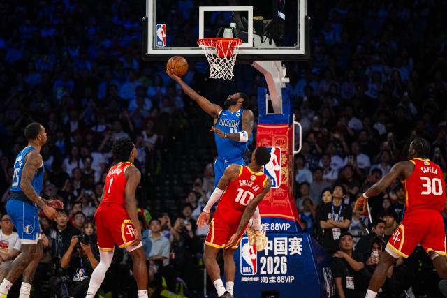 (261011) -- MACAO, Oct. 11, 2026 (Xinhua) -- Kyrie Irving (top) of Dallas Mavericks goes for a layup during the 2026-2027 NBA preseason game between Dallas Mavericks and Houston Rockets in Macao, south China, on Oct. 11, 2026. (Xinhua/Cheong Kam Ka)