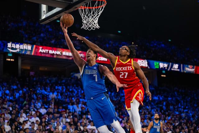 (261011) -- MACAO, Oct. 11, 2026 (Xinhua) -- Dwight Powell (L) of Dallas Mavericks goes for a layup during the 2026-2027 NBA preseason game between Dallas Mavericks and Houston Rockets in Macao, south China, on Oct. 11, 2026. (Xinhua/Cheong Kam Ka)