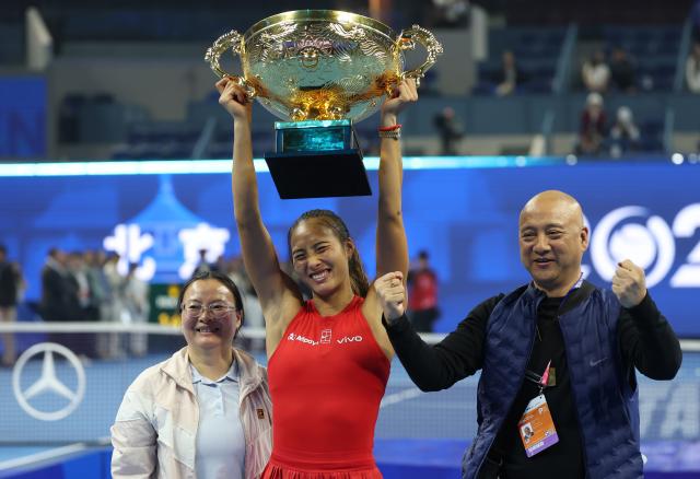 (261011) -- BEIJING, Oct. 11, 2026 (Xinhua) -- Zheng Qinwen (C) poses with the trophy during the awarding ceremony after the women's singles final between Zheng Qinwen of China and Mirra Andreeva of Russia at 2026 China Open tennis tournament in Beijing, China, Oct. 11, 2026. (Xinhua/Zhang Chenlin)