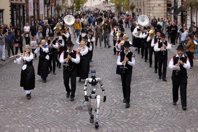 (261011) -- LJUBLJANA, Oct. 11, 2026 (Xinhua) -- A Unitree G1 humanoid robot conducts the Ljubljana Wind Orchestra during the parade of the Ljubljana Wind Orchestra in Ljubljana, Slovenia, Oct. 11, 2026. (Photo by Zeljko Stevanic/Xinhua)