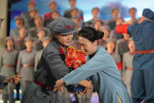 (261012) -- NANCHANG, Oct. 12, 2026 (Xinhua) -- A short performance, titled "Farewell," is staged before the Long March Origin choir's performance at a middle school in Yudu County, east China's Jiangxi Province, Sept. 3, 2026. This year marks the 90th anniversary of the victory of the Long March. As one of its important starting points, Yudu County in east China's Jiangxi Province, a place best known as the starting point of the Long March by the Central Red Army, the historic military maneuver in modern Chinese history, has become more than a place of remembrance.
   It was from Yudu that more than 80,000 Red Army soldiers crossed the Yudu River and began the Long March in 1934, the roughly 12,500-kilometer trek later described by American journalist Harrison Salisbury as "a great human epic."
   On the stone tablet in front of the memorial museum of the Central Red Army's departure for the Long March here in Yudu, three Chinese characters meaning "Long March Origin" are engraved. The "Long March Origin" not only indicates that this place was the starting point of the important strategic transfer of the Red Army at that time, but also carries the profound understanding of the Long March spirit by the people of Yudu to this day.
   You can see the words "Long March Origin" frequently in Yudu, and the Long March Origin choir is a prominent presence.
   In this red revolutionary land of Yudu, almost everyone can share family stories connected to the Red Army's Long March. The Long March Origin choir, established in 2010, is composed of over 100 descendants of Red Army soldiers from all walks of life in the county. Over these years, they have not only performed the "Suite of Songs on the Long March" in Yudu and across Jiangxi in their spare time, but also carried forward the spirit of the Long March along the Long March route with their songs.
   The choir's first performance was staged on June 30, 2011, which was dedicated to the 90th anniversary of the founding of the Communist Party of China. So far the choir has performed over 730 charity performances. "We hope that the choir will complete 1,000 performances by the 100th anniversary of the victory of the Long March," said Zou Weimin, the director of the choir. (Xinhua/Zhou Mi)