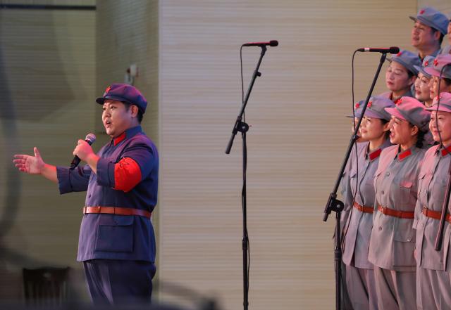 (261012) -- NANCHANG, Oct. 12, 2026 (Xinhua) -- Lai Feihong (1st L), vocal artistic director of the Long March Origin choir, stages a performance at a middle school in Yudu County, east China's Jiangxi Province, Sept. 3, 2026. This year marks the 90th anniversary of the victory of the Long March. As one of its important starting points, Yudu County in east China's Jiangxi Province, a place best known as the starting point of the Long March by the Central Red Army, the historic military maneuver in modern Chinese history, has become more than a place of remembrance.
   It was from Yudu that more than 80,000 Red Army soldiers crossed the Yudu River and began the Long March in 1934, the roughly 12,500-kilometer trek later described by American journalist Harrison Salisbury as "a great human epic."
   On the stone tablet in front of the memorial museum of the Central Red Army's departure for the Long March here in Yudu, three Chinese characters meaning "Long March Origin" are engraved. The "Long March Origin" not only indicates that this place was the starting point of the important strategic transfer of the Red Army at that time, but also carries the profound understanding of the Long March spirit by the people of Yudu to this day.
   You can see the words "Long March Origin" frequently in Yudu, and the Long March Origin choir is a prominent presence.
   In this red revolutionary land of Yudu, almost everyone can share family stories connected to the Red Army's Long March. The Long March Origin choir, established in 2010, is composed of over 100 descendants of Red Army soldiers from all walks of life in the county. Over these years, they have not only performed the "Suite of Songs on the Long March" in Yudu and across Jiangxi in their spare time, but also carried forward the spirit of the Long March along the Long March route with their songs.
   The choir's first performance was staged on June 30, 2011, which was dedicated to the 90th anniversary of the founding of the Communist Party of China. So far the choir has performed over 730 charity performances. "We hope that the choir will complete 1,000 performances by the 100th anniversary of the victory of the Long March," said Zou Weimin, the director of the choir. (Xinhua/Wang Jingqiang)