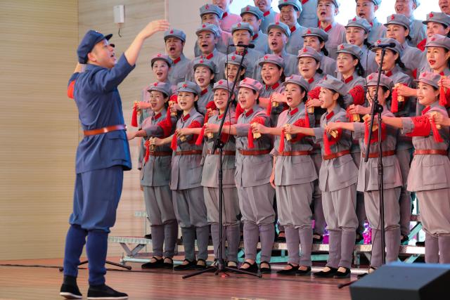 (261012) -- NANCHANG, Oct. 12, 2026 (Xinhua) -- Zou Weimin (1st L), the director of the Long March Origin choir, conducts a performance at a middle school in Yudu County, east China's Jiangxi Province, Sept. 3, 2026. This year marks the 90th anniversary of the victory of the Long March. As one of its important starting points, Yudu County in east China's Jiangxi Province, a place best known as the starting point of the Long March by the Central Red Army, the historic military maneuver in modern Chinese history, has become more than a place of remembrance.
   It was from Yudu that more than 80,000 Red Army soldiers crossed the Yudu River and began the Long March in 1934, the roughly 12,500-kilometer trek later described by American journalist Harrison Salisbury as "a great human epic."
   On the stone tablet in front of the memorial museum of the Central Red Army's departure for the Long March here in Yudu, three Chinese characters meaning "Long March Origin" are engraved. The "Long March Origin" not only indicates that this place was the starting point of the important strategic transfer of the Red Army at that time, but also carries the profound understanding of the Long March spirit by the people of Yudu to this day.
   You can see the words "Long March Origin" frequently in Yudu, and the Long March Origin choir is a prominent presence.
   In this red revolutionary land of Yudu, almost everyone can share family stories connected to the Red Army's Long March. The Long March Origin choir, established in 2010, is composed of over 100 descendants of Red Army soldiers from all walks of life in the county. Over these years, they have not only performed the "Suite of Songs on the Long March" in Yudu and across Jiangxi in their spare time, but also carried forward the spirit of the Long March along the Long March route with their songs.
   The choir's first performance was staged on June 30, 2011, which was dedicated to the 90th anniversary of the founding of the Communist Party of China. So far the choir has performed over 730 charity performances. "We hope that the choir will complete 1,000 performances by the 100th anniversary of the victory of the Long March," said Zou Weimin, the director of the choir. (Xinhua/Wang Jingqiang)