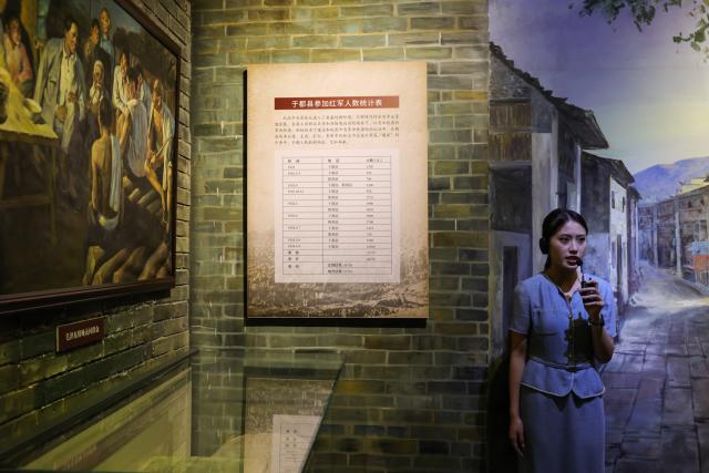 (261012) -- NANCHANG, Oct. 12, 2026 (Xinhua) -- A staff member introduces the story of the Yudu people and the Red Army at the memorial museum of the Central Red Army's departure for the Long March in Yudu County, east China's Jiangxi Province, Sept. 2, 2026. This year marks the 90th anniversary of the victory of the Long March. As one of its important starting points, Yudu County in east China's Jiangxi Province, a place best known as the starting point of the Long March by the Central Red Army, the historic military maneuver in modern Chinese history, has become more than a place of remembrance.
   It was from Yudu that more than 80,000 Red Army soldiers crossed the Yudu River and began the Long March in 1934, the roughly 12,500-kilometer trek later described by American journalist Harrison Salisbury as "a great human epic."
   On the stone tablet in front of the memorial museum of the Central Red Army's departure for the Long March here in Yudu, three Chinese characters meaning "Long March Origin" are engraved. The "Long March Origin" not only indicates that this place was the starting point of the important strategic transfer of the Red Army at that time, but also carries the profound understanding of the Long March spirit by the people of Yudu to this day.
   You can see the words "Long March Origin" frequently in Yudu, and the Long March Origin choir is a prominent presence.
   In this red revolutionary land of Yudu, almost everyone can share family stories connected to the Red Army's Long March. The Long March Origin choir, established in 2010, is composed of over 100 descendants of Red Army soldiers from all walks of life in the county. Over these years, they have not only performed the "Suite of Songs on the Long March" in Yudu and across Jiangxi in their spare time, but also carried forward the spirit of the Long March along the Long March route with their songs.
   The choir's first performance was staged on June 30, 2011, which was dedicated to the 90th anniversary of the founding of the Communist Party of China. So far the choir has performed over 730 charity performances. "We hope that the choir will complete 1,000 performances by the 100th anniversary of the victory of the Long March," said Zou Weimin, the director of the choir. (Xinhua/Wang Jingqiang)