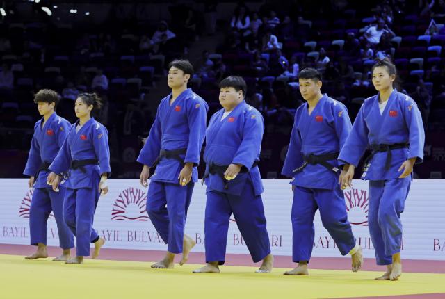 (261012) -- BAKU, Oct. 12, 2026 (Xinhua) -- Six athletes of the Chinese judo team react before the mixed team event at the 2026 World Senior Judo Championships in Baku, Azerbaijan, Oct. 11, 2026. (Xinhua/Chen Junfeng)
