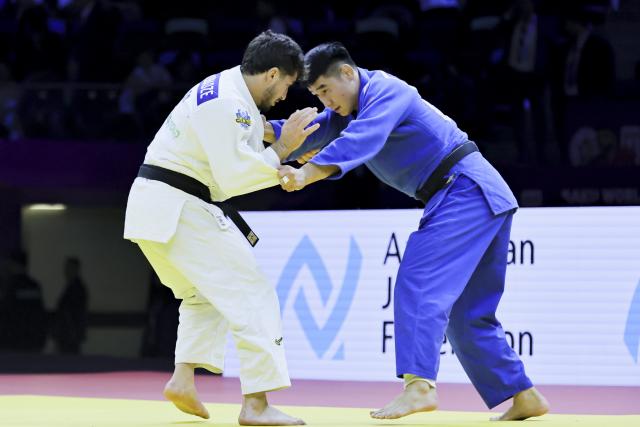 (261012) -- BAKU, Oct. 12, 2026 (Xinhua) -- Bu Hebilige (R) of China competes against Luka Maisuradze of Georgia in the men's -90kg bout of the mixed team bronze medal match at the 2026 World Senior Judo Championships in Baku, Azerbaijan, Oct. 11, 2026. (Xinhua/Chen Junfeng)
