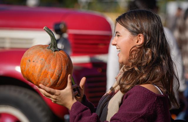 (261012) -- RICHMOND, Oct. 12, 2026 (Xinhua) -- A woman holds a pumpkin at a farm in Richmond, British Columbia, Canada, Oct. 11, 2026. Visiting pumpkin patches is a popular autumn activity in Canada, attracting families to local farms to enjoy the harvest season. (Photo by Liang Sen/Xinhua)