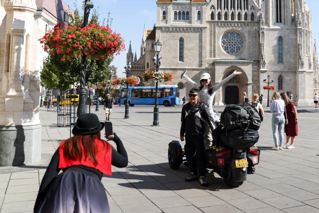 (261012) -- WARSAW, Oct. 12, 2026 (Xinhua) -- A couple from China's Shandong Province poses for photos near Matthias Church in Budapest, Hungary, Oct. 6, 2026. (Xinhua/Hu Zhixuan)