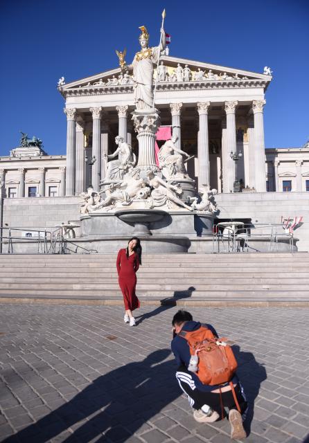 (261012) -- WARSAW, Oct. 12, 2026 (Xinhua) -- A Chinese visitor poses for photos in front of the Austrian Parliament in Vienna, Austria, Oct. 1, 2026. (Xinhua/He Canling)