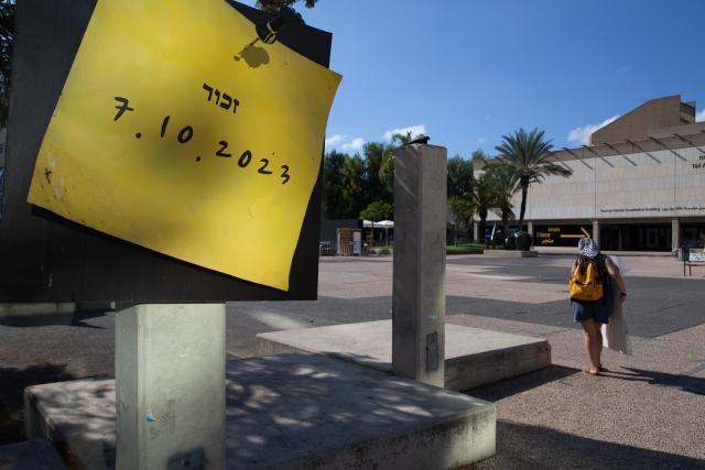 (261012) -- JERUSALEM, Oct. 12, 2026 (Xinhua) -- A pedestrian walks past a memorial site for the latest round of Gaza conflict in Tel Aviv, Israel, Oct. 6, 2026. TO GO WITH "Letter from Mideast: Still waiting for peace near Gaza" (Xinhua/Chen Junqing)