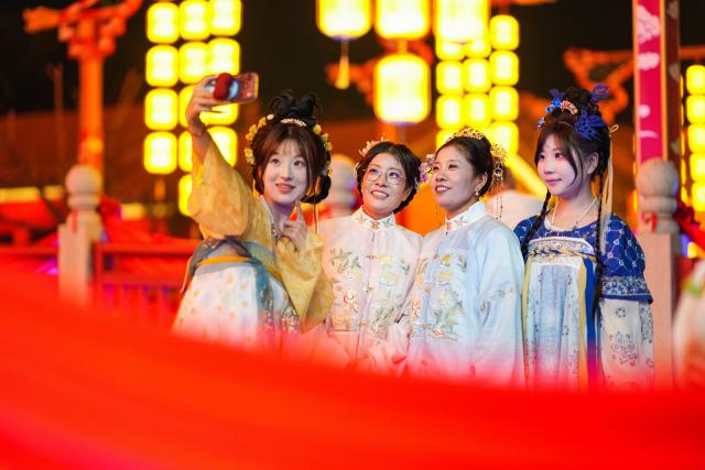 (261012) -- TIANJIN, Oct. 12, 2026 (Xinhua) -- People pose for photos at the Eastern Acropolis in Binhai New Area of Tianjin, north China, Oct. 11, 2026. Eastern Acropolis, a cultural and tourism complex in Beitang ancient town of Tianjin, launched its trial operation on Sunday. The complex, built upon the town's original infrastructure and themed on Tianjin's history and culture, offers immersive performances, cultural experiences, specialty stores and leisure options for visitors. (Photo by Du Penghui/Xinhua)