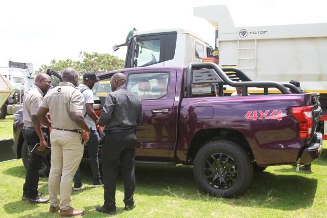 (261012) -- HARARE, Oct. 12, 2026 (Xinhua) -- People view a vehicle on display at the China-Zimbabwe Commodity Expo and Job Fair in Harare, Zimbabwe, on Oct. 9, 2026. Chinese heavy-duty truck brands attracted strong interest from visitors at the three-day China-Zimbabwe Commodity Expo and Job Fair, which concluded Sunday in the Zimbabwean capital of Harare, reflecting growing local demand for reliable commercial vehicles.
   TO GO WITH "Chinese trucks roll into spotlight at Zimbabwe expo" (Photo by Tafara Mugwara/Xinhua)