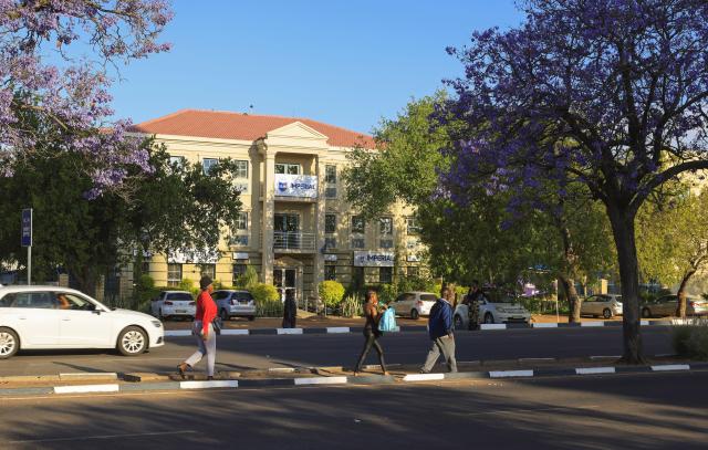 (261012) -- GABORONE, Oct. 12, 2026 (Xinhua) -- People walk on a street in Gaborone, Botswana, Oct. 9, 2026. Gaborone, the capital and the largest city of Botswana, serves as the country's political, economic, cultural and financial center. (Xinhua/Chen Wei)