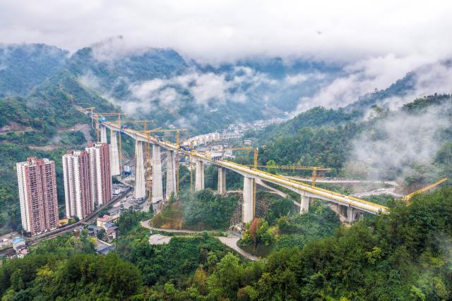 (261012) -- CHONGQING, Oct. 12, 2026 (Xinhua) -- An aerial drone photo taken on Oct. 12, 2026 shows the construction site of the Miaojialiang grand bridge in southwest China's Chongqing Municipality. Located in Chengkou County of Chongqing, the 941.6-meter-long Miaojialiang grand bridge, a key project along the Xi'an-Chongqing high-speed railway, was successfully closed here on Monday. (Xinhua/Tang Yi)