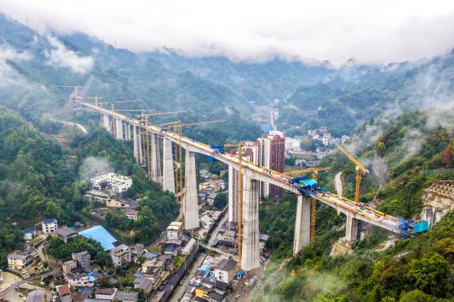 (261012) -- CHONGQING, Oct. 12, 2026 (Xinhua) -- An aerial drone photo taken on Oct. 12, 2026 shows the construction site of the Miaojialiang grand bridge in southwest China's Chongqing Municipality. Located in Chengkou County of Chongqing, the 941.6-meter-long Miaojialiang grand bridge, a key project along the Xi'an-Chongqing high-speed railway, was successfully closed here on Monday. (Xinhua/Tang Yi)