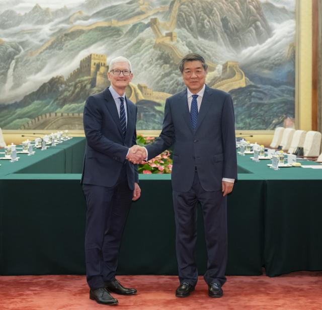 (261012) -- BEIJING, Oct. 12, 2026 (Xinhua) -- Chinese Vice Premier He Lifeng, also a member of the Political Bureau of the Communist Party of China Central Committee, meets with Tim Cook, executive chairman of the board of directors of Apple Inc., at the Great Hall of the People in Beijing, capital of China, Oct. 12, 2026. (Xinhua/Zhai Jianlan)