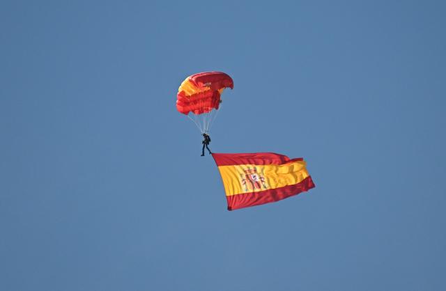 (261012) -- MADRID, Oct. 12, 2026 (Xinhua) -- A paratrooper displays the national flag during a military parade commemorating the National Day in Madrid, Spain, Oct. 12, 2026. (Xinhua/Cheng Min)