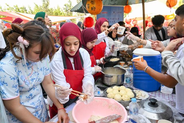 (261012) -- CAIRO, Oct. 12, 2026 (Xinhua) -- Students prepare Chinese snacks for visitors during a Chinese culture festival at Badr University in Cairo, Egypt, Oct. 12, 2026. A Chinese culture festival was held Monday at Badr University in Cairo to celebrate the 70th anniversary of the establishment of diplomatic relations between China and Egypt, featuring cultural performances, traditional Chinese arts and student exchanges. (Xinhua/Xin Mengchen)