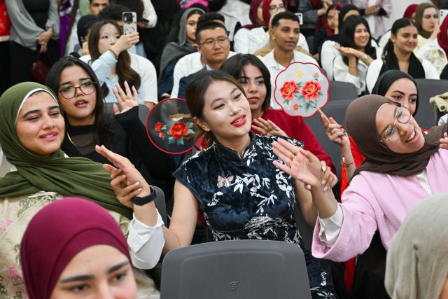 (261012) -- CAIRO, Oct. 12, 2026 (Xinhua) -- People watch a performance during a Chinese culture festival at Badr University in Cairo, Egypt, Oct. 12, 2026. A Chinese culture festival was held Monday at Badr University in Cairo to celebrate the 70th anniversary of the establishment of diplomatic relations between China and Egypt, featuring cultural performances, traditional Chinese arts and student exchanges. (Xinhua/Xin Mengchen)