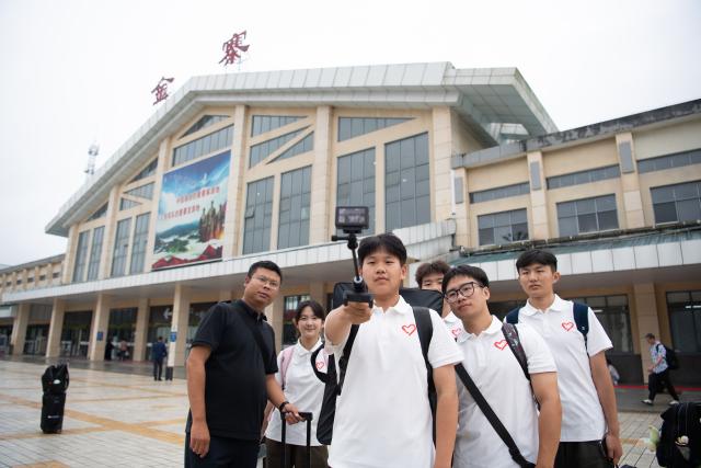(261013) -- JINZHAI, Oct. 13, 2026 (Xinhua) -- Wang Wei (1st L), counselor at the Academy of Fine Arts of Anhui Normal University, arrives with members of a volunteer team in Jinzhai County of east China's Anhui Province, Sept. 26, 2026. During this year's Mid-Autumn Festival holiday, a volunteer team from the Academy of Fine Arts of Anhui Normal University was busy in Jinzhai County of Lu'an City in east China's Anhui Province, drawing portraits of Red Army martyrs who participated in the Long March, the historic military maneuver in modern Chinese history, and presented them to the families of the martyrs.
   Since November 2021, the Academy of Fine Arts of Anhui Normal University has formed a team to carry out a series of volunteer services focused on drawing portraits of martyrs. Up to now, hundreds of students have participated in these activities, jointly drawing more than 600 portraits of martyrs, which have become an important way for their families to express feelings of longing.
   Across time and space, the youthful faces of those who had fallen on the battlefield were finally seen again by their families back home.
   Tucked in the Dabie Mountains, Jinzhai county contributed tens of thousands of people to the Communist Party of China (CPC)-led revolution in the first half of the 20th century. A total of 12 main units of the Red Army originated from here.
   Now, the Anhui Normal University project to paint portraits of Red Army martyrs is giving some families a long-awaited face to go with the stories passed down for generations. Usually the volunteer team would first contact the relatives of martyrs and then study photographs of the martyrs' descendants to determine basic facial contours. They would then revise the portraits repeatedly, drawing on family descriptions of the martyrs' eyes, expressions and habitual looks, until these relatives feel the likeness is right.
   For teachers and students of the team, painting portraits of martyrs is not merely a simple sketch creation but also an immersive study tour of revolutionary history. The brows and eyes rendered by the artists' brushes have captured the youthful appearance of the martyrs and also provided a place for the remembrance to rest. The past events recounted by the relatives of the martyrs are a testament to the enduring revolutionary legacy of the Dabie Mountains from generation to generation. (Xinhua/Zhang Duan)