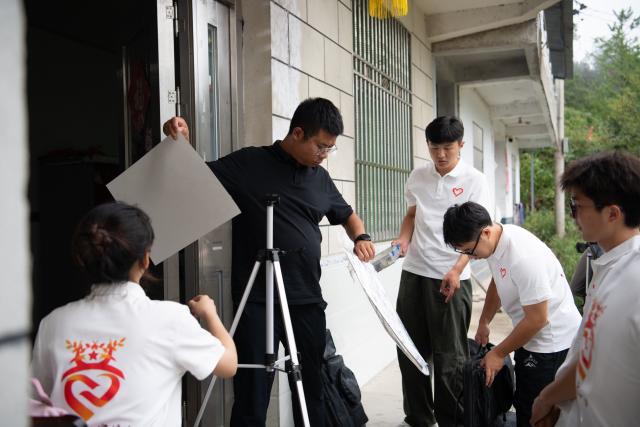 (261013) -- JINZHAI, Oct. 13, 2026 (Xinhua) -- Members of the volunteer team prepare to create a portrait of Hu Jiufu, a Red Army martyr who took part in the Long March, in Baojiyan Village of Tangjiahui Town, Jinzhai County of east China's Anhui Province, Sept. 26, 2026. During this year's Mid-Autumn Festival holiday, a volunteer team from the Academy of Fine Arts of Anhui Normal University was busy in Jinzhai County of Lu'an City in east China's Anhui Province, drawing portraits of Red Army martyrs who participated in the Long March, the historic military maneuver in modern Chinese history, and presented them to the families of the martyrs.
   Since November 2021, the Academy of Fine Arts of Anhui Normal University has formed a team to carry out a series of volunteer services focused on drawing portraits of martyrs. Up to now, hundreds of students have participated in these activities, jointly drawing more than 600 portraits of martyrs, which have become an important way for their families to express feelings of longing.
   Across time and space, the youthful faces of those who had fallen on the battlefield were finally seen again by their families back home.
   Tucked in the Dabie Mountains, Jinzhai county contributed tens of thousands of people to the Communist Party of China (CPC)-led revolution in the first half of the 20th century. A total of 12 main units of the Red Army originated from here.
   Now, the Anhui Normal University project to paint portraits of Red Army martyrs is giving some families a long-awaited face to go with the stories passed down for generations. Usually the volunteer team would first contact the relatives of martyrs and then study photographs of the martyrs' descendants to determine basic facial contours. They would then revise the portraits repeatedly, drawing on family descriptions of the martyrs' eyes, expressions and habitual looks, until these relatives feel the likeness is right.
   For teachers and students of the team, painting portraits of martyrs is not merely a simple sketch creation but also an immersive study tour of revolutionary history. The brows and eyes rendered by the artists' brushes have captured the youthful appearance of the martyrs and also provided a place for the remembrance to rest. The past events recounted by the relatives of the martyrs are a testament to the enduring revolutionary legacy of the Dabie Mountains from generation to generation. (Xinhua/Zhang Duan)
