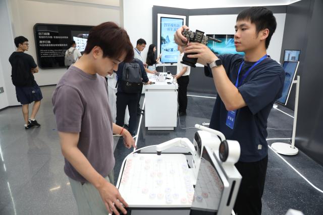 (261013) -- NANNING, Oct. 13, 2026 (Xinhua) -- A visitor plays a board game with a robot at the China-ASEAN Countries Artificial Intelligence (AI) Application Cooperation Center in Nanning, south China's Guangxi Zhuang Autonomous Region, Oct. 12, 2026. Located in Nanning City, the China-ASEAN Countries Artificial Intelligence (AI) Application Cooperation Center serves as an important platform for south China's Guangxi Zhuang Autonomous Region to implement the national AI development strategy and deepen China-ASEAN cooperation in AI. (Xinhua/Lu Peng)
