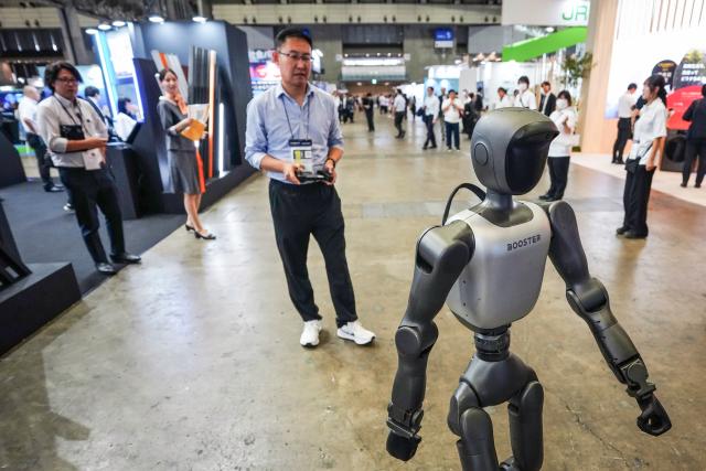 (261013) -- CHIBA, Oct. 13, 2026 (Xinhua) -- An exhibitor controls a humanoid robot at the Combined Exhibition of Advanced Technologies (CEATEC) 2026 in Chiba Prefecture, Japan, Oct. 13, 2026. The CEATEC 2026 kicked off here on Tuesday. (Xinhua/Jia Haocheng)