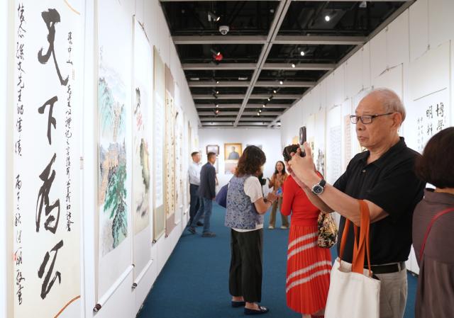 (261013) -- HONG KONG, Oct. 13, 2026 (Xinhua) -- People visit an exhibition of calligraphy and paintings commemorating the 160th anniversary of the birth of Sun Yat-sen, in Hong Kong, south China, Oct. 13, 2026. TO GO WITH "Art exhibition marks 160th birth anniversary of Sun Yat-sen in Hong Kong" (Photo by Wang Shen/Xinhua)