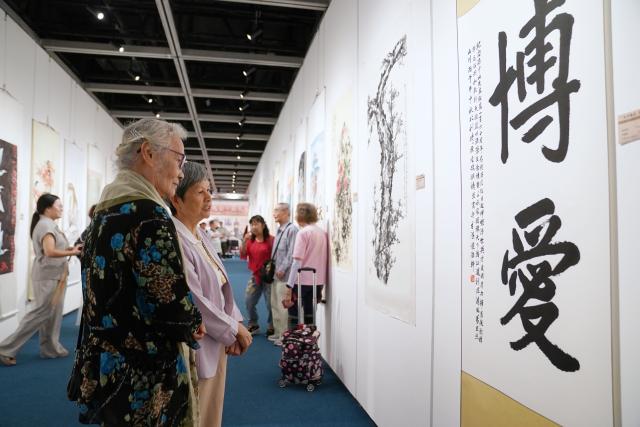 (261013) -- HONG KONG, Oct. 13, 2026 (Xinhua) -- People visit an exhibition of calligraphy and paintings commemorating the 160th anniversary of the birth of Sun Yat-sen, in Hong Kong, south China, Oct. 13, 2026. TO GO WITH "Art exhibition marks 160th birth anniversary of Sun Yat-sen in Hong Kong" (Photo by Wang Shen/Xinhua)
