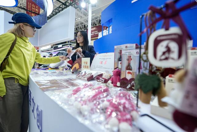 (261013) -- YINCHUAN, Oct. 13, 2026 (Xinhua) -- A visitor buys wine-themed cultural and creative products at the sixth China (Ningxia) International Wine Culture and Tourism Expo in Yinchuan, northwest China's Ningxia Hui Autonomous Region, Oct. 13, 2026.
  From Oct. 12 to 14, the expo is held in Yinchuan, attracting 84 world-renowned wineries and enterprises from distinctive production areas in 16 countries. It has also drawn a total of 146 leading domestic wineries from Ningxia and other core production areas in China.
 The local wine industry has also become a driver of tourism. Wineries in Ningxia receive more than 3.7 million tourist visits each year, generating combined benefits of over 50 billion yuan (around 7.4 billion U.S. dollars). (Xinhua/Yang Zhisen)