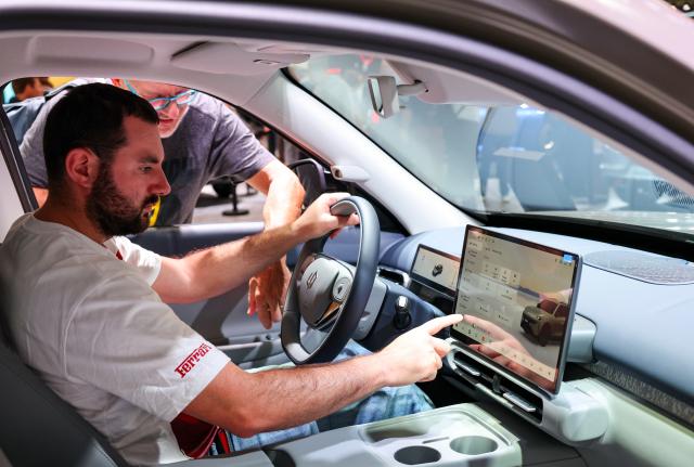 (261013) -- PARIS, Oct. 13, 2026 (Xinhua) -- Visitors try out a vehicle at the booth of Chinese automaker Leapmotor during the 2026 Paris Motor Show in Paris, France, on Oct. 13, 2026. The 91st Paris Motor Show opened in the French capital on Monday, with a record number of Chinese automakers taking part to showcase their latest models and technologies. (Xinhua/Wu Huiwo)