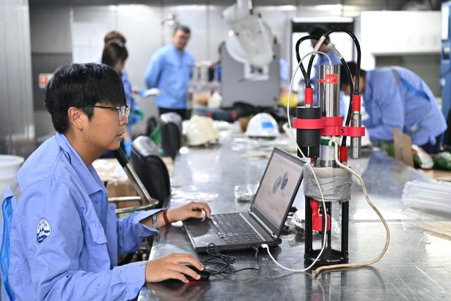 (261013) -- ABOARD RESEARCH VESSEL DEEP SEA NO. 1, Oct. 13, 2026 (Xinhua) -- A staff member processes a data collector of the manned deep-sea submersible Jiaolong aboard the research vessel Deep Sea No. 1, on Oct. 11, 2026. China's manned deep-sea submersible Jiaolong successfully completed its 467th dive. The dive reached a depth of approximately 4,400 meters. (Xinhua/Li Xin)